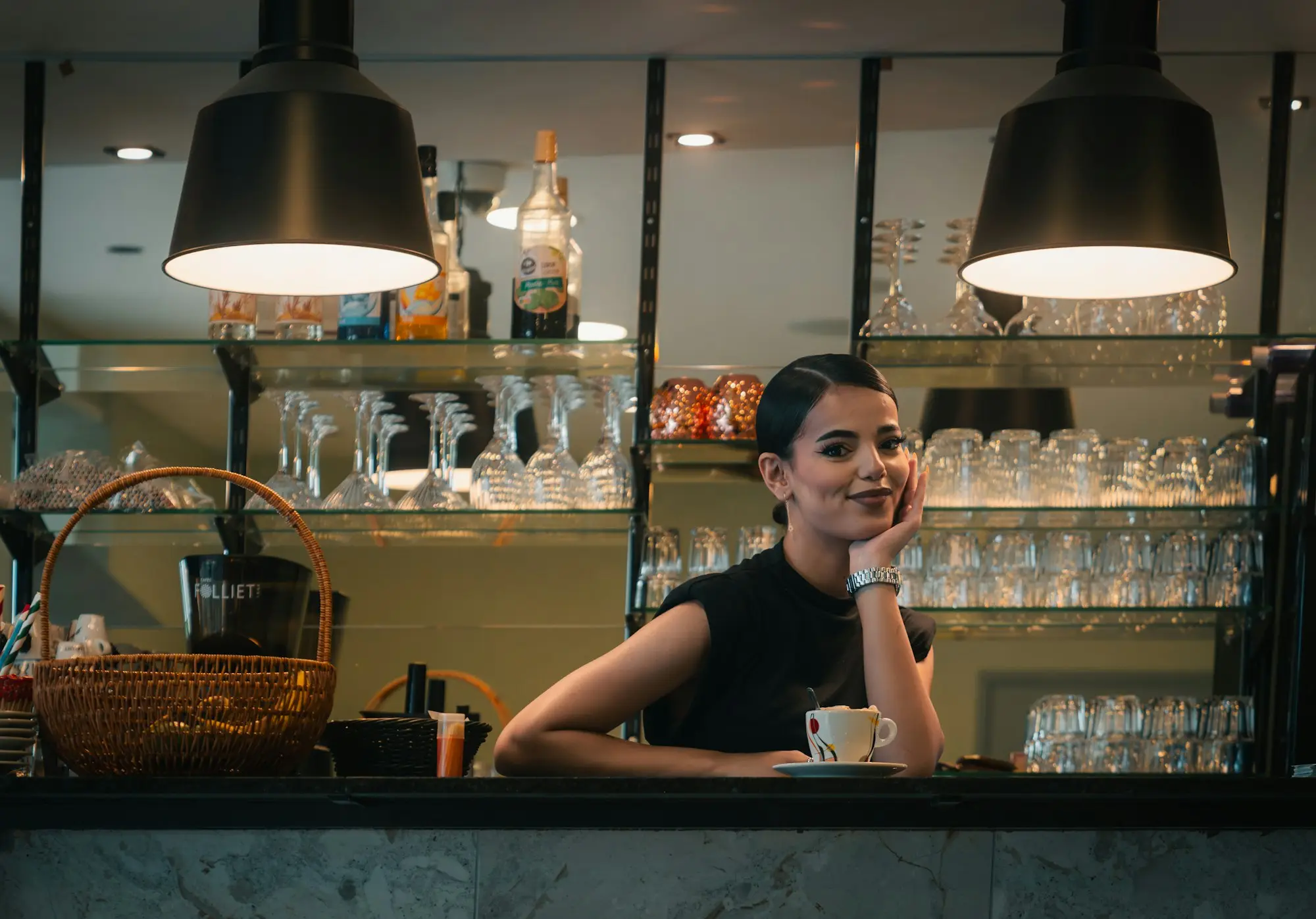 Café owner leaning on the counter with a coffee