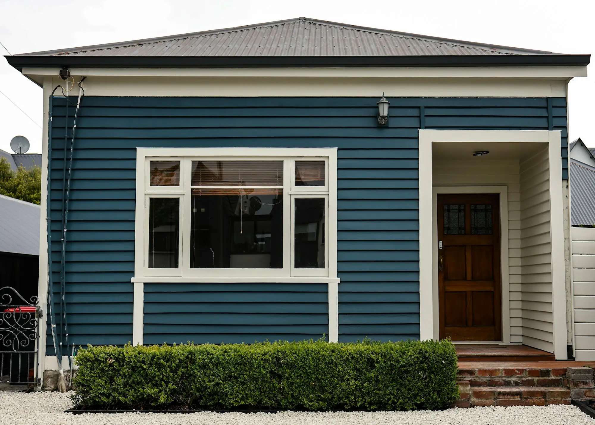 Blue weatherboard villa with white trim